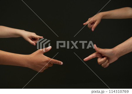 Closeup of diverse children's hands pointing, showing their index fingers against black background. Closeup of diverse children's hands pointing, showing their index fingers against black background. 114310769