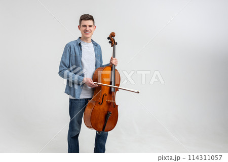 Attractive man musician playing cello on concert Attractive man musician playing cello on concert 114311057