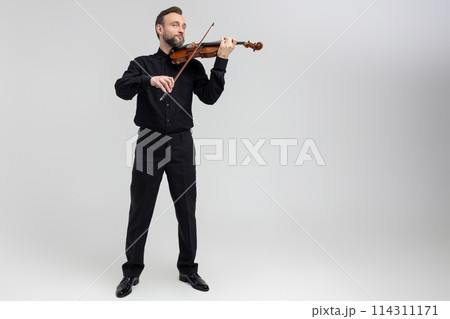 Adult man in black shirt playing violin Adult man in black shirt playing violin 114311171