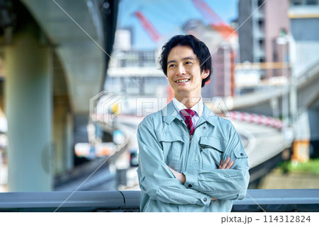 高速道路の前で腕組みする若い技術者 114312824