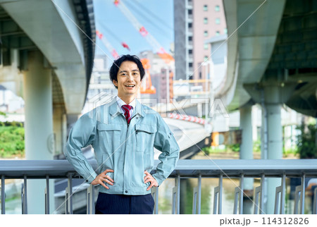 高速道路の前で腕組みする若い技術者 高速道路の前で腕組みする若い技術者 114312826