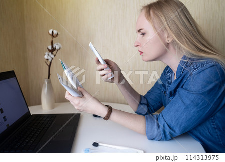 Toothpaste ingredients. Girl at laptop checks composition of toothpaste and is surprised by dangerous composition of product. Emulsifiers, preservatives, dyes, PEG, SLS, parabens, diethanolamine Toothpaste ingredients. Girl at laptop checks composition of toothpaste and is surprised by dangerous composition of product. Emulsifiers, preservatives, dyes, PEG, SLS, parabens, diethanolamine 114313975