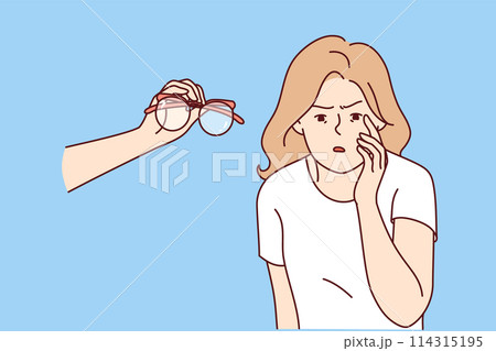 Blind woman with poor vision looks closely at small text, standing near hand with glasses 114315195