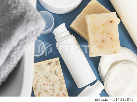 White pump cosmetic bottle near soap bars on blue countertop in bathroom, mockup 114315879