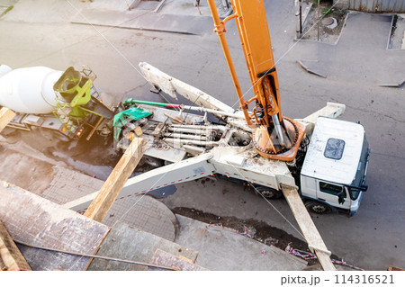 Top-Down Perspective: Concrete Pump Truck Transfers Mixer Truck Load for Floor Pouring at Construction Site. 114316521