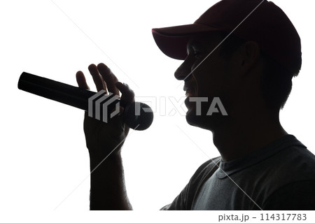 Young man in cap singing into a microphone 114317783