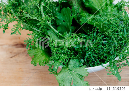 Green fresh mix lettuce salad leaves in white bowl. Green fresh mix lettuce salad leaves in white bowl. 114319393