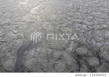 the frozen surface of the river in the winter season 114320723