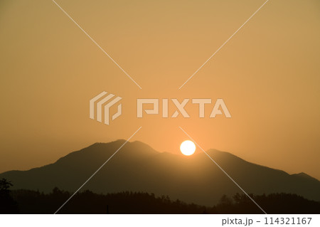 朝の光が空を黄金色に染め茅ヶ岳の鞍部から昇る太陽 114321167
