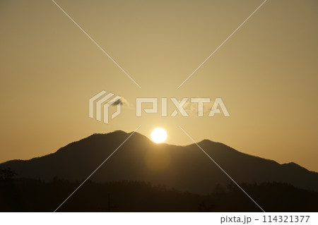 朝の光が空を黄金色に染め茅ヶ岳の鞍部から昇る太陽 114321377