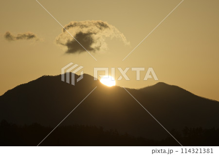 朝の光が空を黄金色に染め茅ヶ岳の鞍部から昇る太陽 114321381