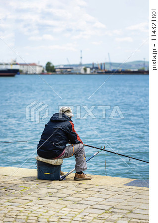 Fisherman on pier, back view. Leisure time, relaxing on fishing Fisherman on pier, back view. Leisure time, relaxing on fishing 114321801