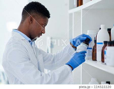 Scientist, chemical and black man with bottle in lab for medical research, information and healthcare. Chemistry, medicine and person in science with thinking for production, innovation or experiment 114322220