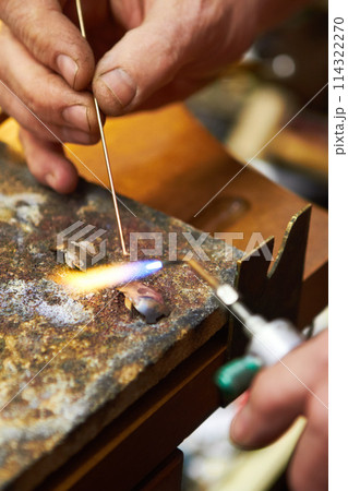 Hands, jewelry and closeup of torch metal for creative art.manufacturing, steel process in workshop. Fingers, expert and equipment for silver heating or handmade business, flame craft or iron design 114322270