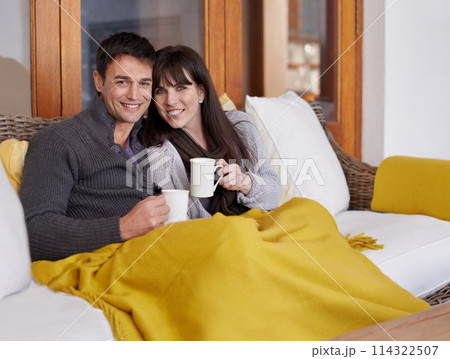 Portrait, love and happy couple relax on a sofa with trust support or bonding with coffee or blanket at home. Smile, face or people in living room with security, safety and chilling together with tea Portrait, love and happy couple relax on a sofa with trust support or bonding with coffee or blanket at home. Smile, face or people in living room with security, safety and chilling together with tea 114322507