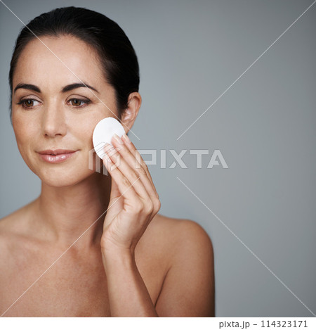 Mature woman, pad and hygiene in studio, skin care and facial treatment on gray background. Female person, cotton and swab for grooming in daily routine, mockup space and dermatology to remove makeup Mature woman, pad and hygiene in studio, skin care and facial treatment on gray background. Female person, cotton and swab for grooming in daily routine, mockup space and dermatology to remove makeup 114323171