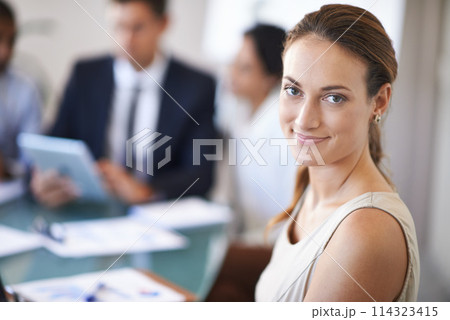 Shes a team player. a businesswoman smiling during a meeting with her colleagues. 114323415