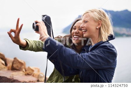 Happy woman, friends and laughing with peace sign or camera for funny photography or moments together in nature. Female person with smile for photo, picture or memories of emoji on outdoor holiday Happy woman, friends and laughing with peace sign or camera for funny photography or moments together in nature. Female person with smile for photo, picture or memories of emoji on outdoor holiday 114324750