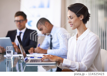 Woman, boardroom and smile with typing on laptop to brainstorm for presentation, paperwork and teamwork. Business people, office and personal assistant in table with strategy for company growth. 114325423