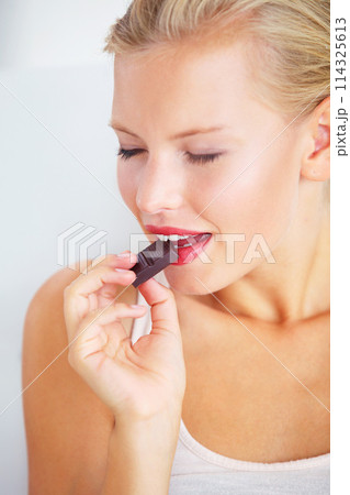 Relax woman face, eating and enjoy chocolate bar, delicious snack or studio wellness candy, junk food or dessert product. Diet nutrition, sugar addiction temptation or female person bite cacao sweets 114325613