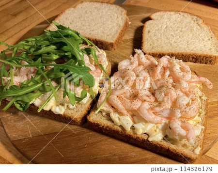 Sandwiches with shrimp, egg and arugula salad on wooden background Sandwiches with shrimp, egg and arugula salad on wooden background 114326179