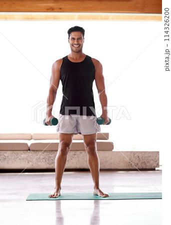 Man, portrait and dumbbell workout or weightlifting routine in home or healthy training, athlete or exercise. Male person, face and equipment or wellness strong or muscle growth, warm up or practice 114326200