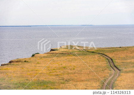 dirt road leading to the edge of a cliff above the water dirt road leading to the edge of a cliff above the water 114326313