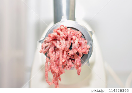 minced meat production process in an electric meat grinder 114326396