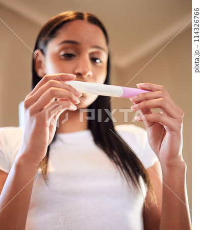 Anxiety, woman and hands with pregnancy test in home for results, scared or nervous for ivf fail. Maternity, stress and serious person waiting with worry, fear and frustrated for mistake in low angle 114326766