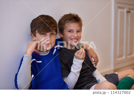 Children, portrait and friends with food in sports uniform for relax break in apartment or match, training or exercise. Male people, boys and face or eating snack in house or soccer, practice or meal Children, portrait and friends with food in sports uniform for relax break in apartment or match, training or exercise. Male people, boys and face or eating snack in house or soccer, practice or meal 114327002