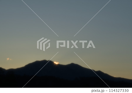 日の出直前の茅ヶ岳。山並みの樹々、雲が輝く 114327330