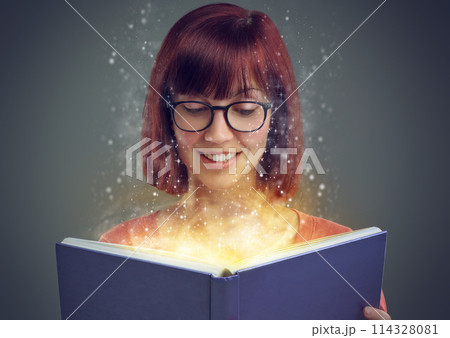 Glowing pages, book and woman with a story, fantasy and education on grey studio background. Person, reader and girl with a novel and literature with knowledge or creativity with glasses or astrology 114328081