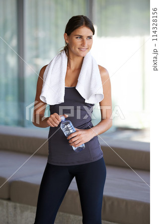 Fitness, thinking and happy woman with water, towel and commitment to body, yoga and workout. Gym, bottle and girl with exercise, training and pilates for health, wellness and drinking with smile 114328156