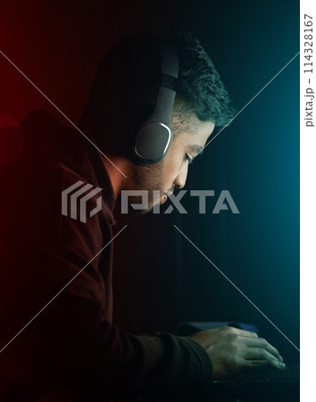 Esports, man and gamer on computer at night for competition in rpg video games or virtual challenge. Gaming, nerd and hacker typing in dark for cyber contest in home with neon light or tech mockup 114328167