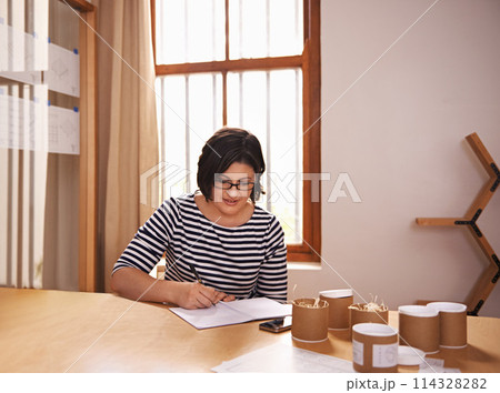 Businesswoman, sample and planning at desk, product and notes for startup business. Administration, research and inventory for female brand owner in office, paper and writing for quality control 114328282