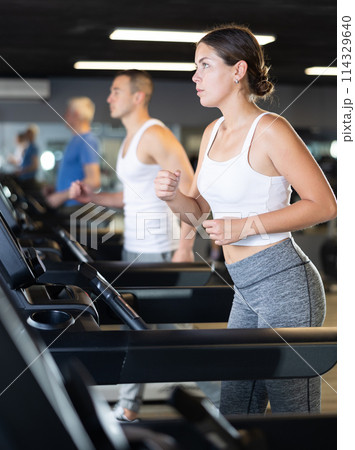 Young woman exercising on treadmill in gym Young woman exercising on treadmill in gym 114329640