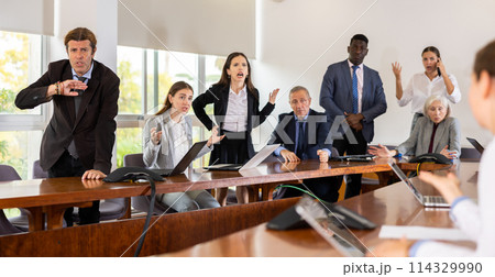 Businesspeople arguing at meeting in office 114329990