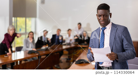 Portrait of depressed businessman in suit with documents 114330064