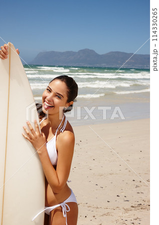 Woman, beach and surfboard for surfing or portrait with happiness, adventure and bikini with blue sky. Tourist, person and surfer by ocean in morning for holiday, vacation and freedom in California 114330265