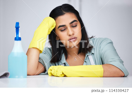 Woman, sleeping and tired cleaner with spray bottle for table, kitchen counter or dirty furniture in home. Burnout, exhausted maid and lazy Indian janitor on break with product, liquid soap or gloves 114330427