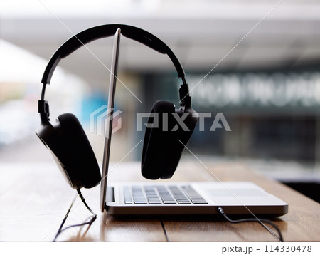 Laptop, work and headphones closeup on table at cafe or coffee shop for productivity online. Internet, streaming and computer on desk on campus at college or university with technology to study 114330478