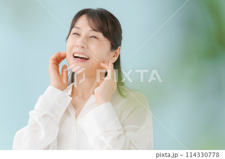 頬杖をついて微笑む女性 114330778