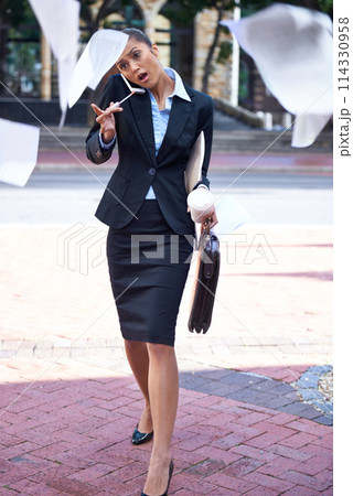 Paper, busy or businesswoman in city to multitask or street for phone call, travel or morning commute. Lawyer, drop or late attorney walking to rush with documents falling, crisis or flying in air 114330958