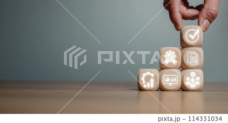 QA, Quality management assurance concept, Hand holding wooden block on desk with quality management assurance icon on virtual screen. 114331034