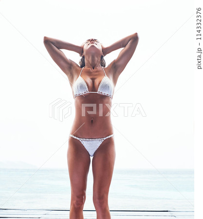 Travel, bikini and woman at beach on summer vacation, holiday or weekend trip in Maldives. Freedom, confident and slim female person in swimwear for swimming outdoor by ocean or sea by coast. 114332376