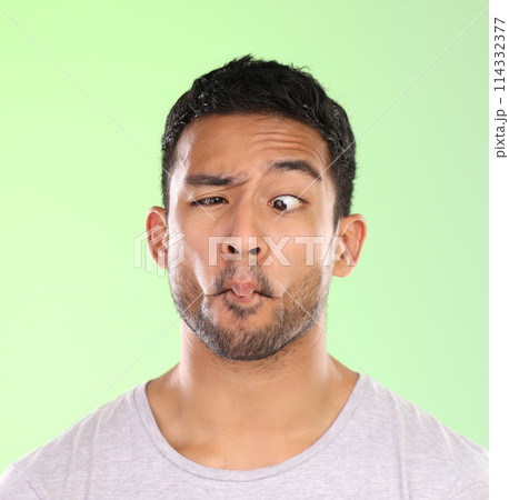 Man, funny and comic face in studio with silly, goofy and emoji mouth with fun attitude for humor. Model, person and facial expression for comedy, joke and confidence with mockup on green background 114332377