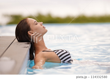 Summer, peace and woman relax in swimming pool on luxury holiday or vacation at hotel or villa in Cancun. Person, outdoor or enjoy calm water at resort in Mexico or girl in bikini or swimsuit fashion 114332580