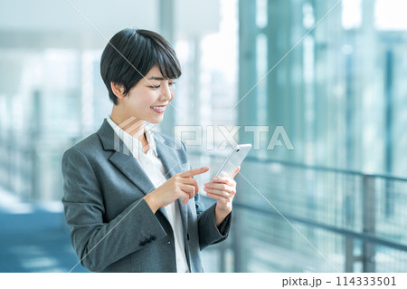 スマホを持つビジネスパーソンの女性。 スマホを持つビジネスパーソンの女性。 114333501