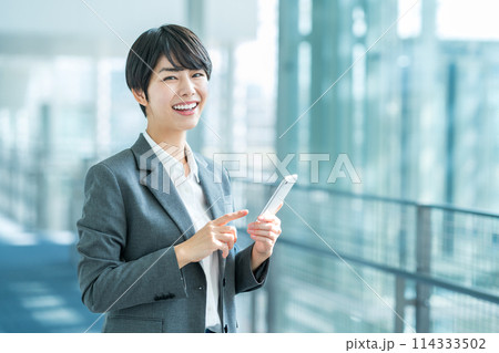 スマホを持つビジネスパーソンの女性。 スマホを持つビジネスパーソンの女性。 114333502