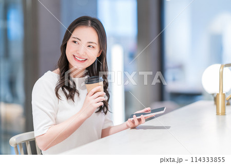 カフェでスマホを操作する若い女性。撮影協力：WEEK芝大門（サンフロンティア不動産） 114333855